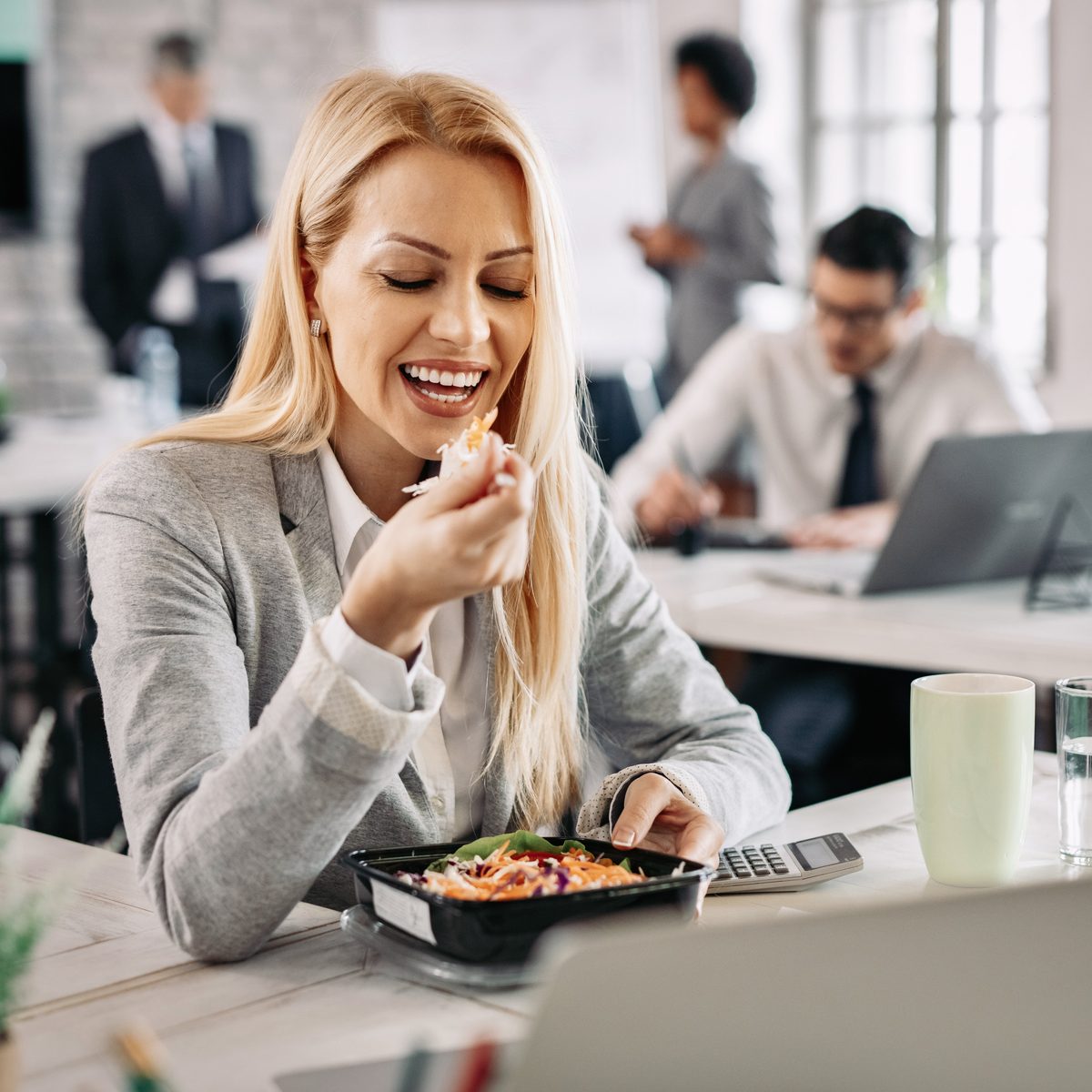 Collaboratrice déjeunant une lunchbox Allo Cantine au bureau à Casablanca